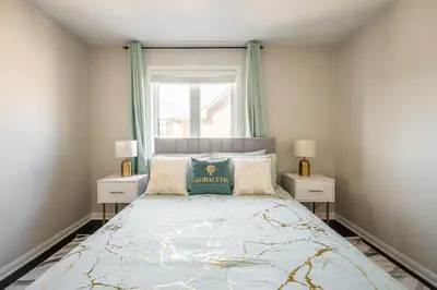 a bedroom with a bed with two night stands and a window at GlobalStay 3 Bedroom House with Parking Brampton in Brampton