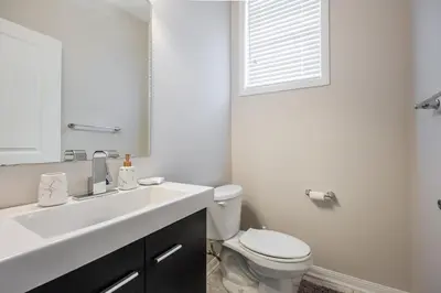 a white bathroom with a toilet and a sink at GlobalStay 3 Bedroom House with Parking Brampton in Brampton