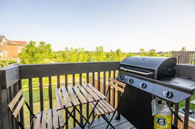 a grill and a wooden bench on a balcony at GlobalStay 3 Bedroom House with Parking Brampton in Brampton