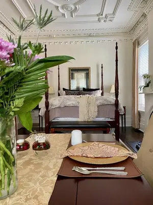 a bedroom with a bed and a table with flowers at Norfolk Guest House Inn in Guelph