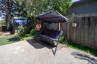 a chair under an umbrella in a backyard at Private room with TVnetflix and free parking in Pickering