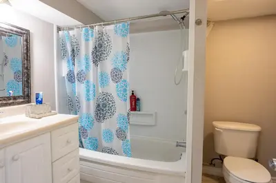 a bathroom with a shower curtain and a toilet at Private room with TVnetflix and free parking in Pickering
