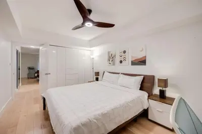 a bedroom with a bed and a ceiling fan at Prime Location 2BR with KingBed in Vibrant Toronto in Toronto