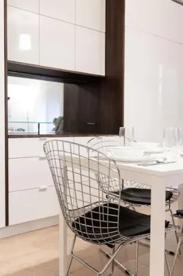 a white kitchen with a white table and chairs at Prime Location 2BR with KingBed in Vibrant Toronto in Toronto