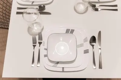 a table with a white plate with forks and spoons at Prime Location 2BR with KingBed in Vibrant Toronto in Toronto