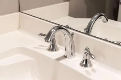 a bathroom sink with two faucets and a mirror at Prime Location 2BR with KingBed in Vibrant Toronto in Toronto