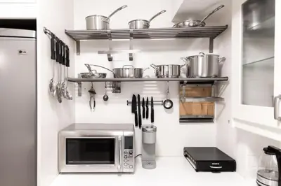 a kitchen with pots and pans on a wall at Prime Location 2BR with KingBed in Vibrant Toronto in Toronto