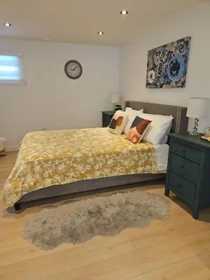 a bedroom with a bed and a table with a night stand at Riverfront Cottage Sauna Canoe Included Kids Playroom Nature Escape in Wasaga Beach