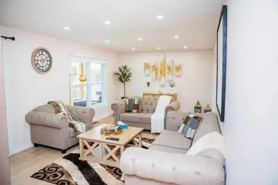a living room with two couches and a table at Riverfront Cottage Sauna Canoe Included Kids Playroom Nature Escape in Wasaga Beach