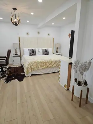 a bedroom with a bed and a wooden floor at Riverfront Cottage Sauna Canoe Included Kids Playroom Nature Escape in Wasaga Beach