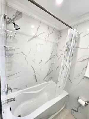 a white bathroom with a tub and a shower at Toronto Uptown 1 - Bus to Downtown in Toronto
