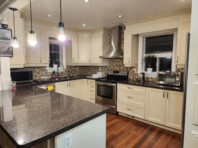 a kitchen with white cabinets and granite counter tops at Toronto Uptown 1 - Bus to Downtown in Toronto