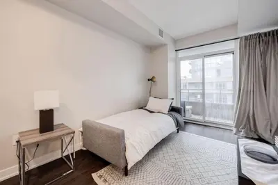 a bedroom with a bed and a large window at City Serenity 1 Bedroom with Balcony in Toronto