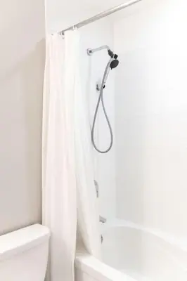 a white bathroom with a shower curtain and a toilet at City Serenity 1 Bedroom with Balcony in Toronto