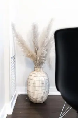 a vase with feathers in it next to a chair at City Serenity 1 Bedroom with Balcony in Toronto