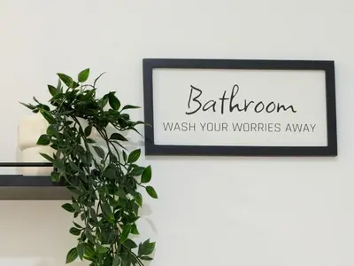 a black and white sign on a wall with a plant at Modern Townhome at Wintergreen Sauna Steps from Blue Mountain Village in Blue Mountains
