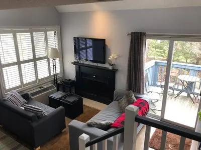 a living room with a couch and a flat screen tv at Blue Mountain Escape, WIFI, Base of North lift in Blue Mountains