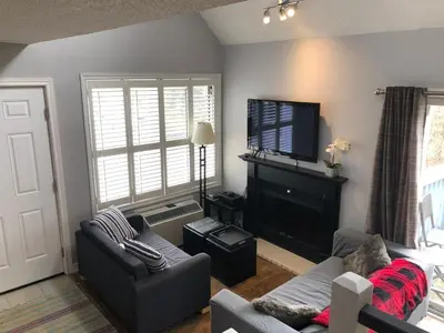 a living room with a couch and a flat screen tv at Blue Mountain Escape, WIFI, Base of North lift in Blue Mountains