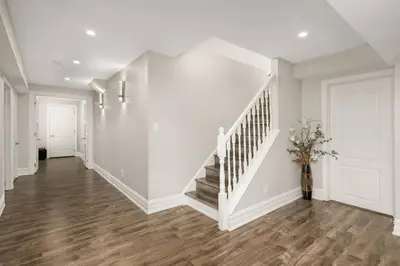 a hallway with white walls and a white stair case at Walk-out Basement Apartment with Private Entrance in Brampton