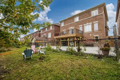 a large brick house with two chairs in the yard at Walk-out Basement Apartment with Private Entrance in Brampton