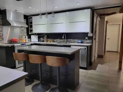 a kitchen with a large sink and two bar stools at Anthropocene Jewel Cottage in Milton