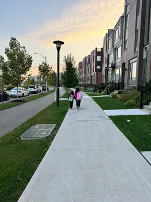 a woman and child walking down a sidewalk at King Bed TV Private Ensuite Retreat Bathroom or Economical Double Bed Room in Toronto