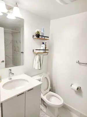 a white bathroom with a toilet and a sink at King Bed TV Private Ensuite Retreat Bathroom or Economical Double Bed Room in Toronto