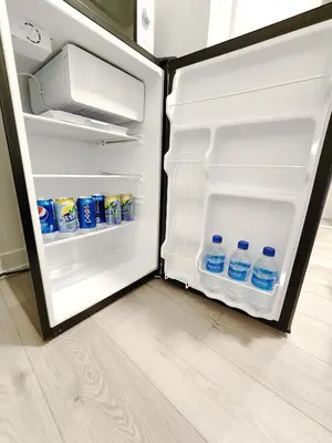 an open refrigerator with bottles of water in it at King Bed TV Private Ensuite Retreat Bathroom or Economical Double Bed Room in Toronto