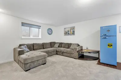 a living room with a couch and a chair at Modern 1 Bedroom + Den in Cambridge in Cambridge