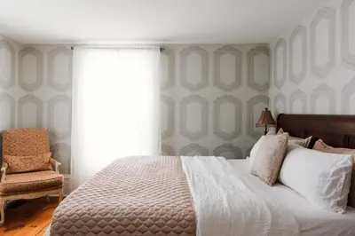 a bedroom with a bed and a chair and a window at Little Louis - A Princely Take on a County Getaway in Mountain View