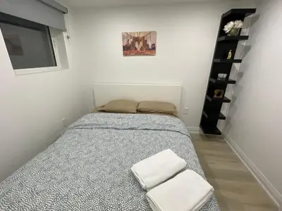 a bedroom with a bed with two white towels at Executive Apartment - 2BDR Parking Self-check in - Walkout basement Lower Unit in Mississauga