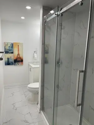 a bathroom with a toilet and a glass shower at Executive Apartment - 2BDR Parking Self-check in - Walkout basement Lower Unit in Mississauga