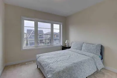 a bedroom with a bed and a large window at Modern NEW Build in Caledonia in Caledonia