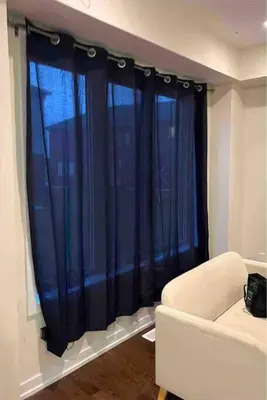 a living room with blue curtains and a couch at Modern NEW Build in Caledonia in Caledonia