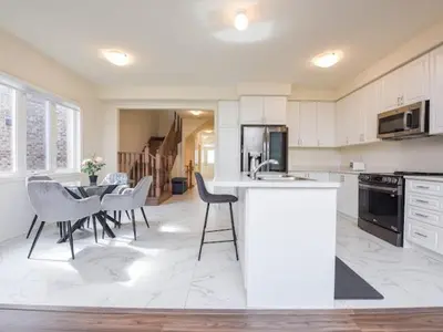 a kitchen with a table and chairs and a dining room at Stylish Home in Waterdown in Hamilton