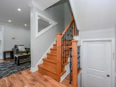 a living room with a wooden staircase and a door at Elegant Home in Mississauga in Mississauga