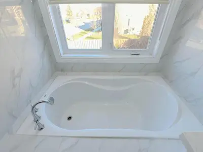 a white bath tub in a bathroom with a window at Elegant Home in Mississauga in Mississauga