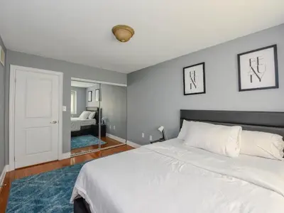 a bedroom with a large white bed and a room with a bed sqor at Elegant Home in Mississauga in Mississauga