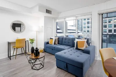 a living room with a blue couch and a table at Chic 1-BR Condo; Parking included; Downtown Core in Toronto