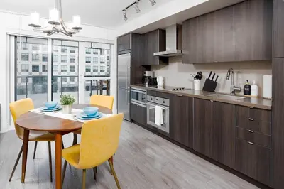 a kitchen with a wooden table and yellow chairs at Chic 1-BR Condo; Parking included; Downtown Core in Toronto