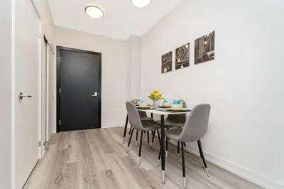 a dining room with a table and chairs and a black door at Luxury 1BR King Bed Unit - Private Balcony in Kitchener
