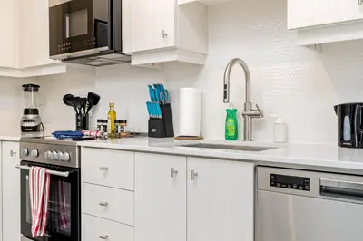 a kitchen with white cabinets and a sink at Luxury 1BR King Bed Unit - Private Balcony in Kitchener