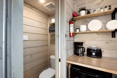 a small kitchen with a toilet and a microwave at Little Cabin in the Pines in Chatsworth