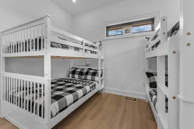 a bedroom with two bunk beds and a window at Sherkston Oasis - Hot Tub Soaks & Luxurious Escape in Port Colborne