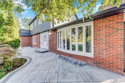 a brick house with a patio and a brick wall at Stunning 7 Br RougeView Home with 2 Kitchens, 5 Bathrooms, Amazing Backyard & 8-Car Parking in Toronto