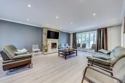 a living room with two couches and a tv at Stunning 7 Br RougeView Home with 2 Kitchens, 5 Bathrooms, Amazing Backyard & 8-Car Parking in Toronto