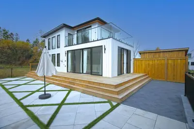 a house with a deck and an umbrella at Sherkston Bliss - Hot Tub Soaks & Backyard BBQ Fun in Port Colborne