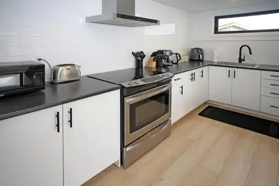 a kitchen with white cabinets and stainless steel appliances at Sherkston Bliss - Hot Tub Soaks & Backyard BBQ Fun in Port Colborne