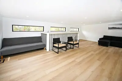 a living room with a couch and a table and chairs at Sherkston Bliss - Hot Tub Soaks & Backyard BBQ Fun in Port Colborne