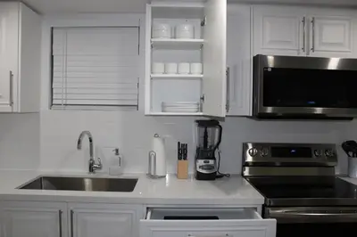 a kitchen with white cabinets and a sink and a microwave at Comfyhome in Vaughan